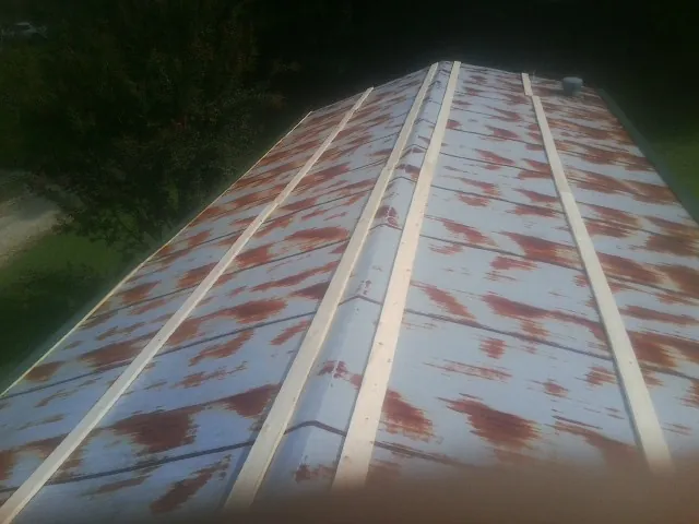 Rusted metal roof panels with new wood purlins before replacement — Storm Damage Roof Repair in Pattersonville by Roofing Brothers