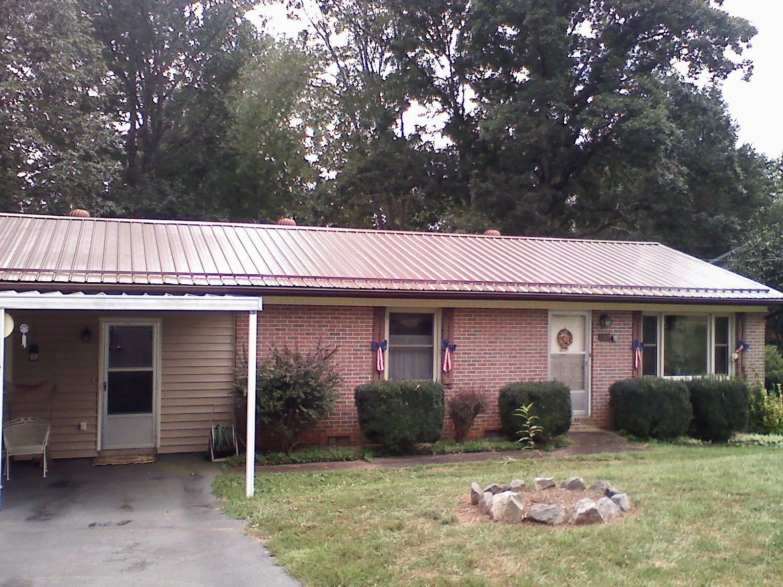Bronze metal roof and carport on a brick ranch home — Roof Repair work by our crew in Pattersonville