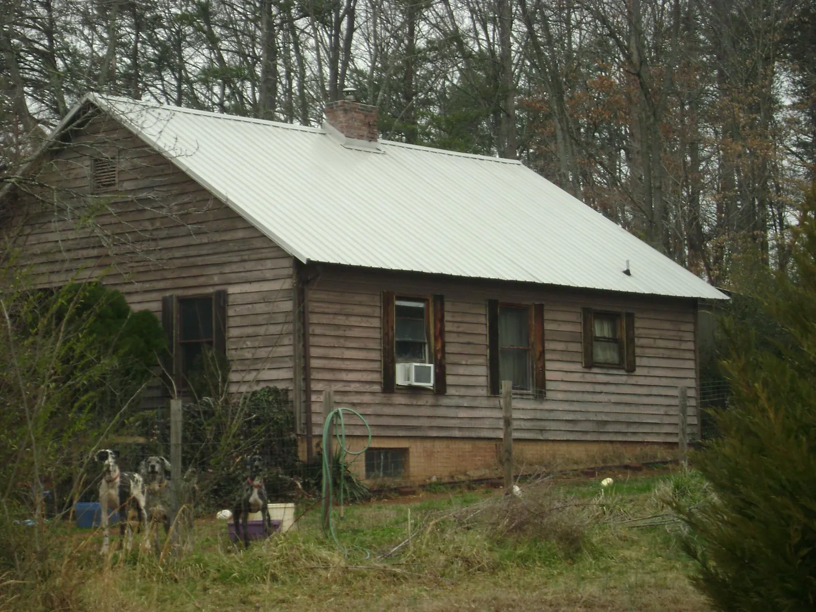 White metal roof on an old wood sided farmhouse, from a Metal Roof Installation job in Pattersonville